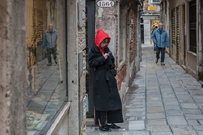 Venedig Passantin mit roter Kapuze in Altstadtgasse
